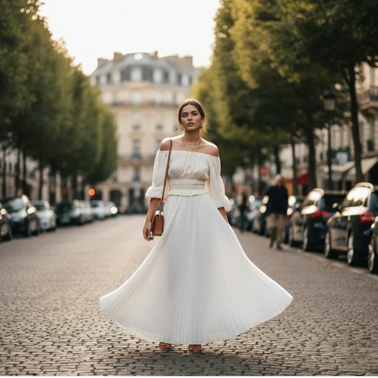 Femme portant une jupe longue blanche fluide avec un haut élégant, look chic et moderne en extérieur.